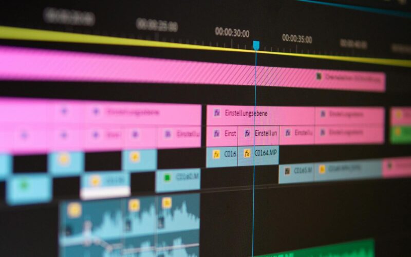 Videoeditor klipper film i Adobe Premiere Pro på laptop