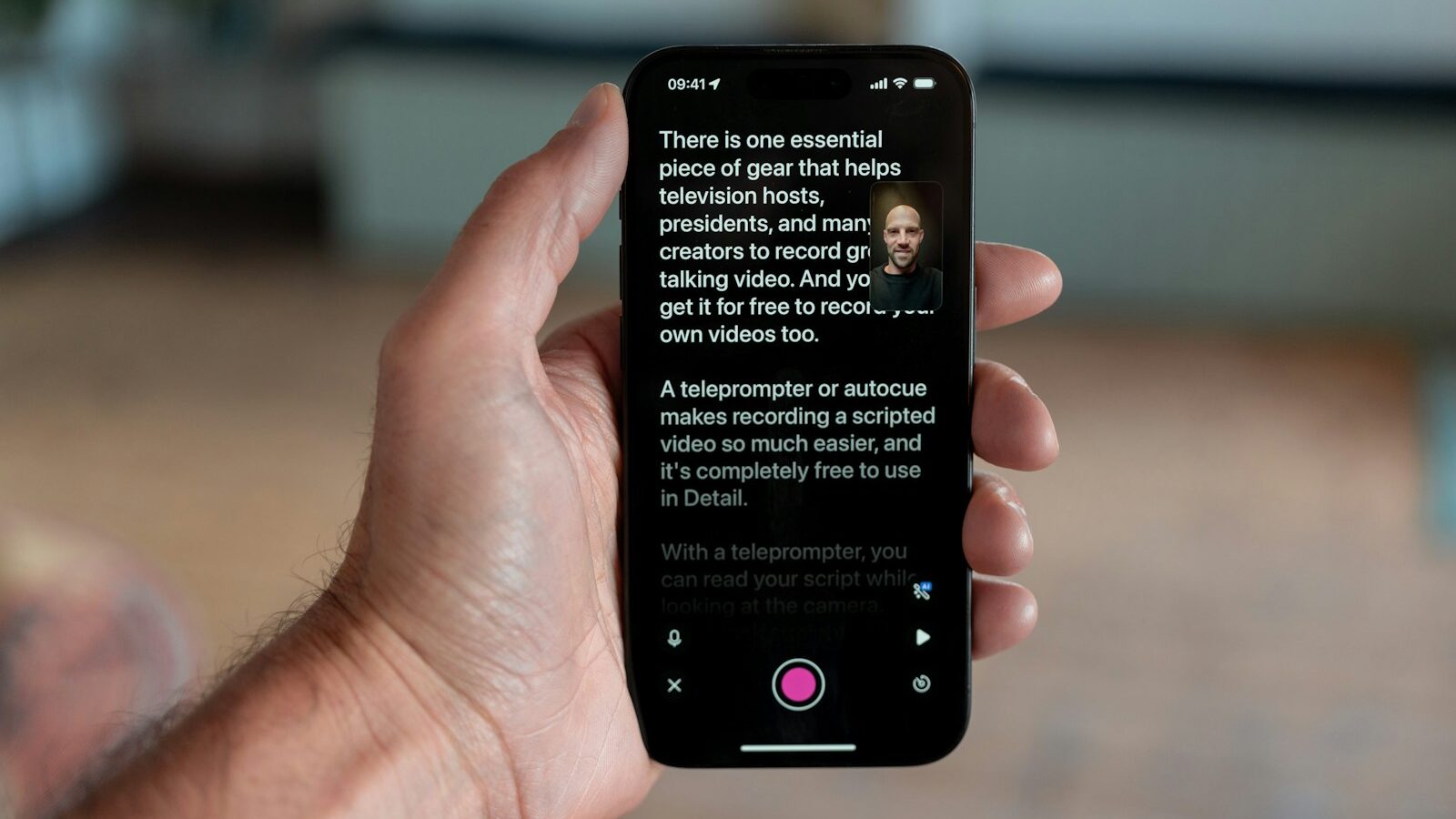 Hånd der holder smartphone med teleprompter-app åbent under videooptagelse